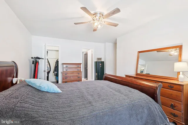a bedroom with a bed and a large mirror on the dresser
