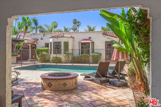 a view of a house with pool and sitting area