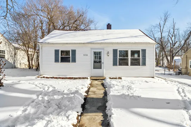 a front view of a house with a snow in the yard
