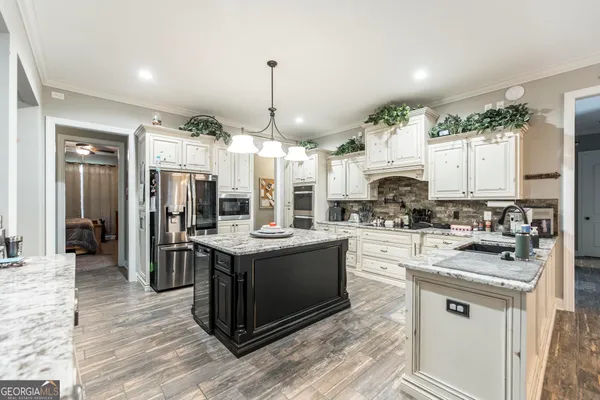 a kitchen with stainless steel appliances granite countertop a refrigerator and a stove