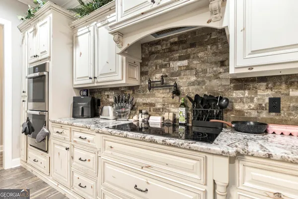 a dining room with chandelier and wooden floor