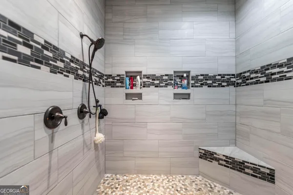 a view of a hallway with wooden floor and a bathroom