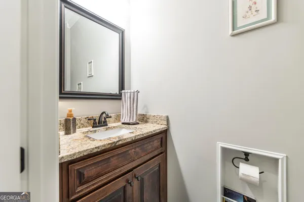 a view of a hallway to a livingroom with wooden floor and furniture
