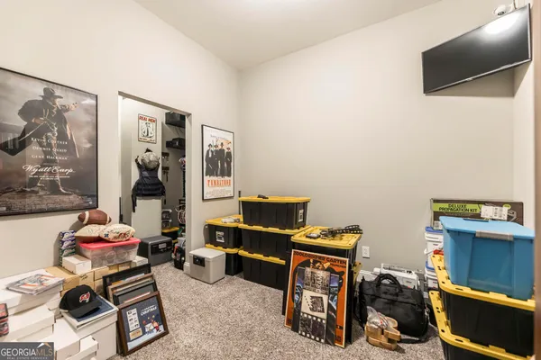 a view of a big room with windows and chandelier fan
