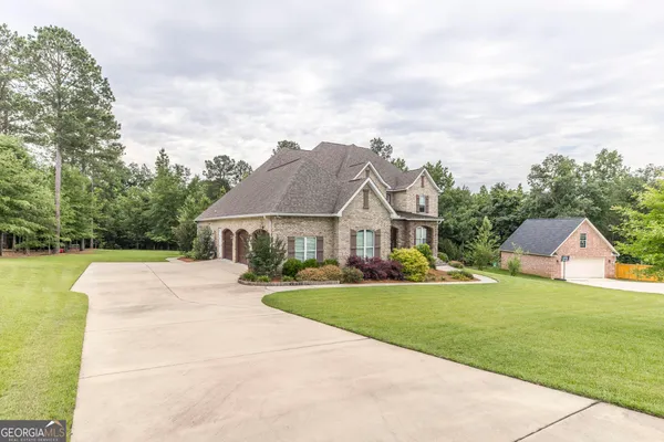 a aerial view of a house with a big yard plants and large trees
