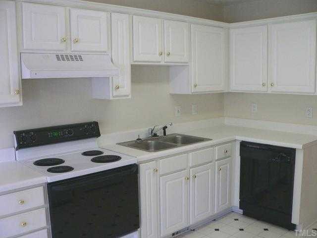 6742 Queen Annes Drive Raleigh, NC 27613 - Photo 5 of 12 a kitchen with white cabinets and appliances