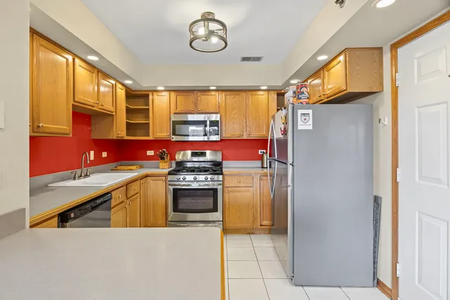 a kitchen with stainless steel appliances granite countertop a refrigerator and a stove