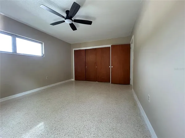 an empty room with closet and windows
