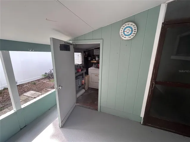 a view of a hallway to a livingroom with furniture