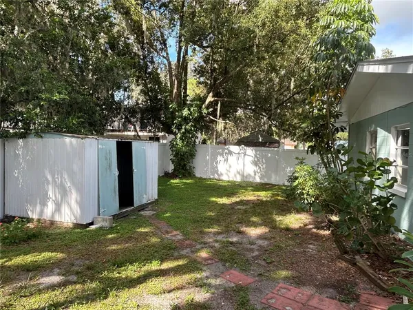 a view of a back yard with an tree and fence