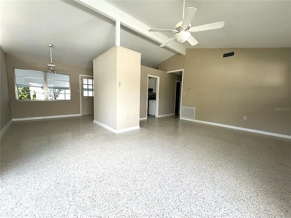 en empty room with windows and ceiling fan