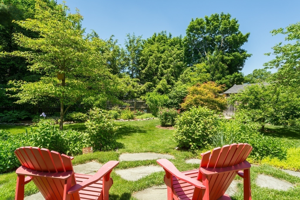 16 Beverly Road Natick, MA 01760 - Photo 31 of 37 a backyard of a house with table and chairs plants and large trees