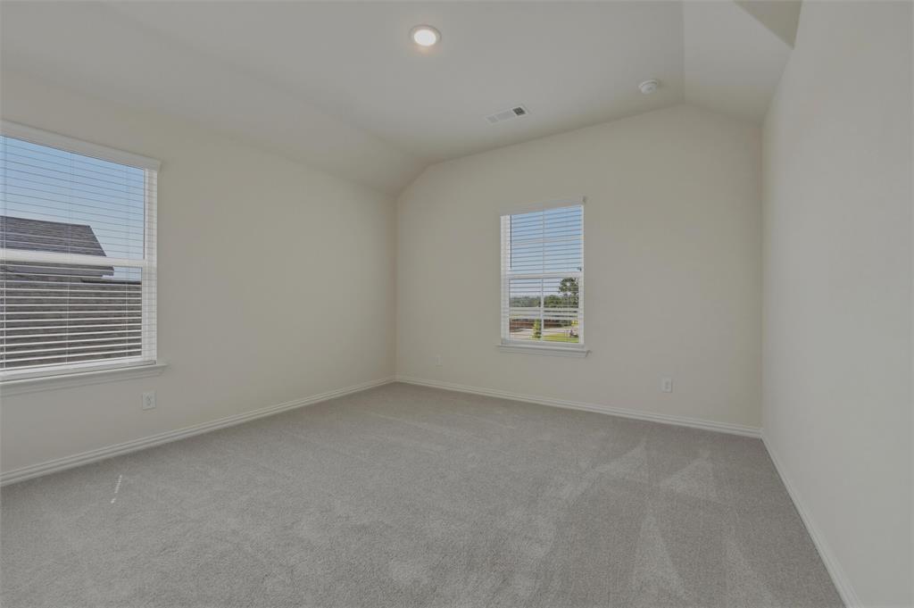 1113 Trinity Drive Springtown, TX 76082 - Photo 22 of 40 Vaulted ceiling, recessed lighting, two windows with blinds, and light-tone carpeting