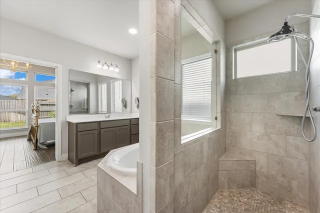 a spacious bathroom with a granite countertop sink a mirror and a shower