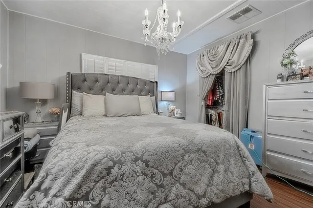 a bedroom with a large bed and a chandelier