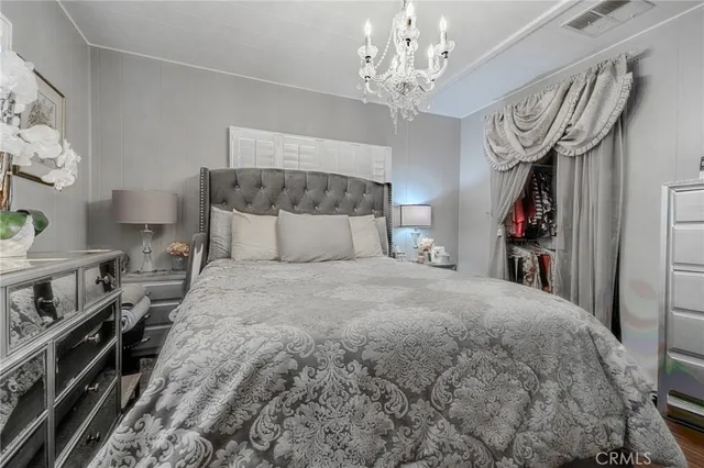 a bedroom with a large bed and a chandelier