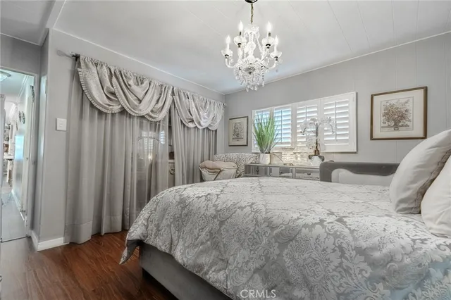a bedroom with a large bed and a chandelier