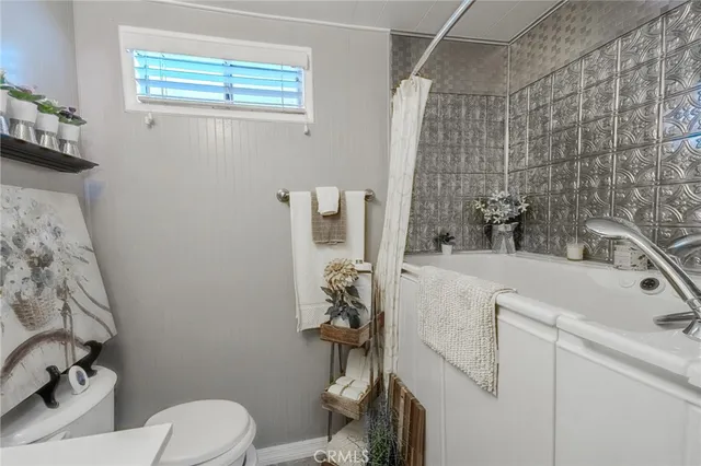 a bathroom with a sink a toilet and shower curtain