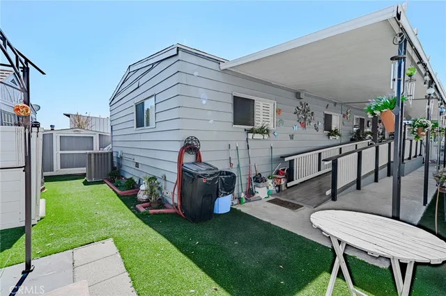 a view of a chair and table in backyard of the house