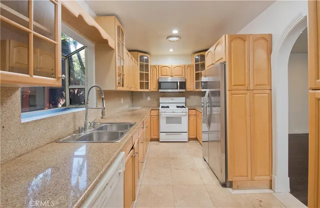 a kitchen with stainless steel appliances granite countertop a refrigerator and a sink