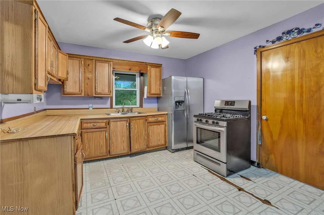 1901 Kimball Road Southeast Canton, OH 44707 - Photo 11 of 32 Kitchen featuring appliances with stainless steel finishes, a sink, ceiling fan, and brown cabinets