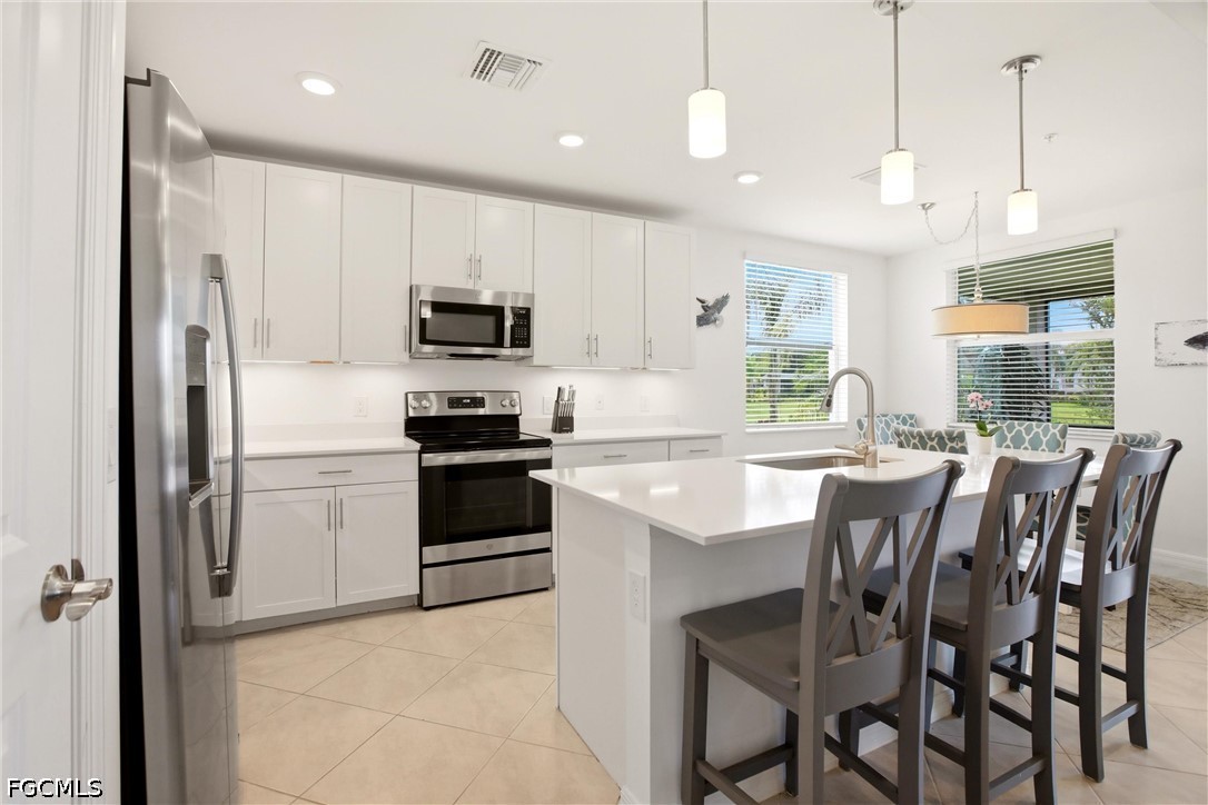 3751 Pebblebrook Ridge Court, Unit 101 Fort Myers, FL 33905 - Photo 8 of 48 a kitchen with a stove a sink and a refrigerator
