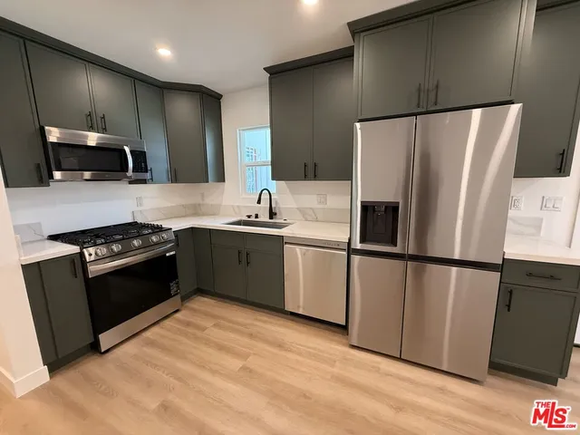a kitchen with stainless steel appliances a refrigerator stove microwave and sink