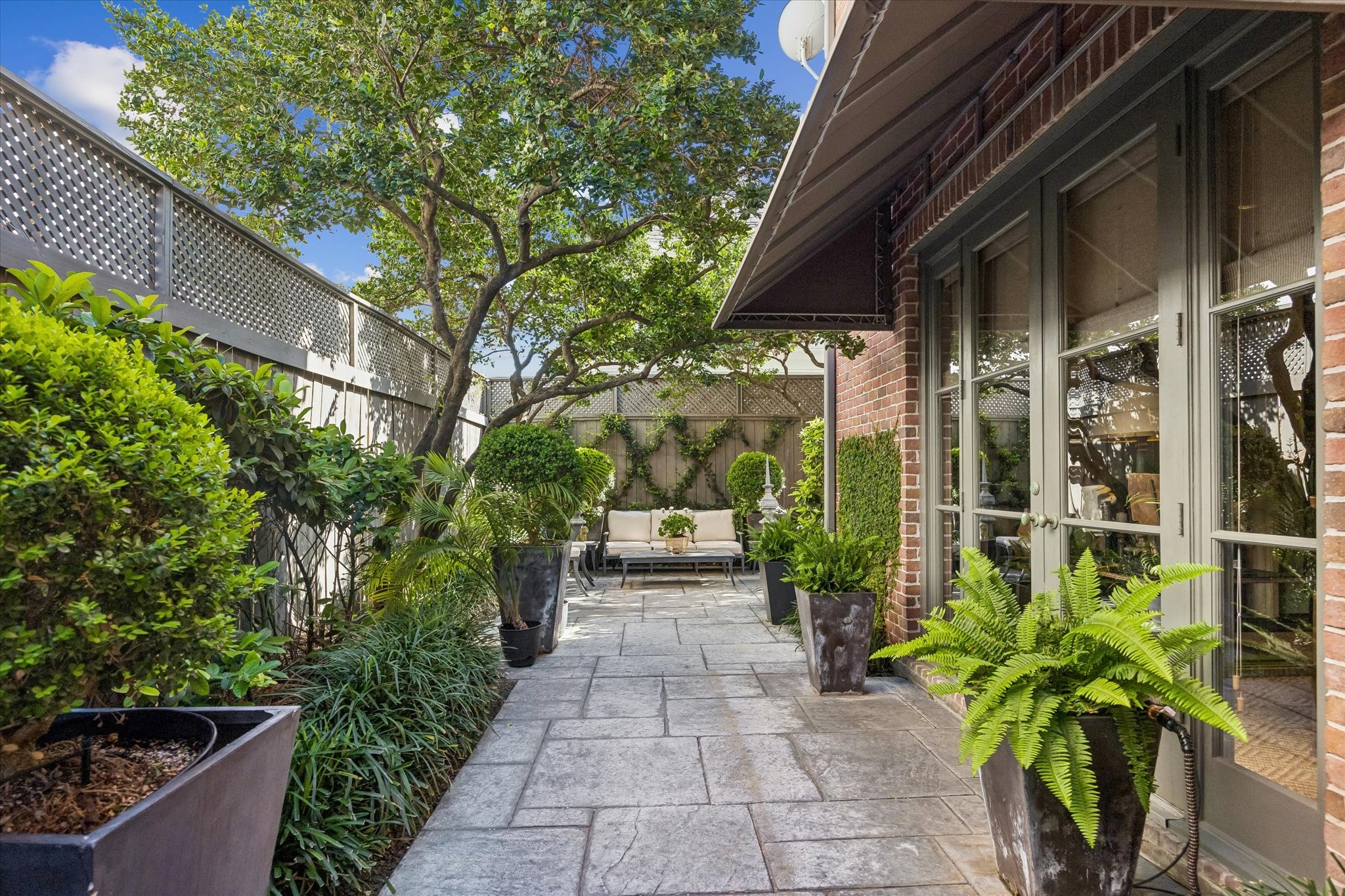 2627 Sutton Court Houston, TX 77027 - Photo 29 of 34 Step outside to a meticulously maintained backyard, where a serene and relaxed atmosphere creates the perfect setting for entertaining or enjoying time with loved ones.