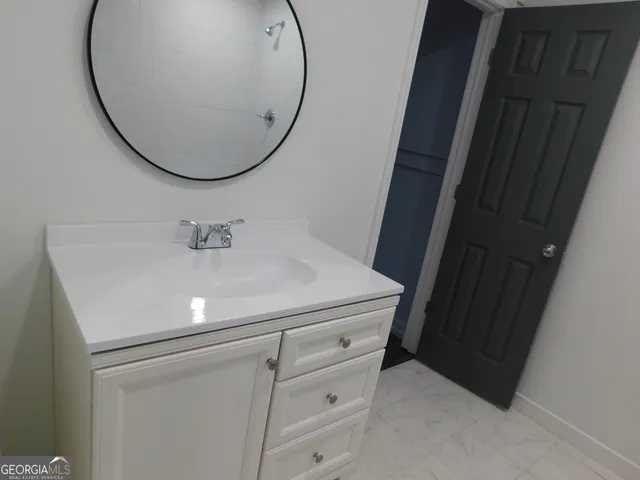 an empty room with wooden floor cabinet and windows