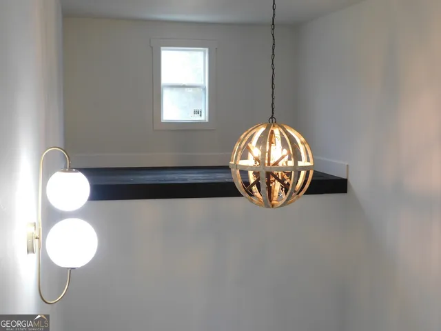 a view of an empty room with wooden floor and stairs