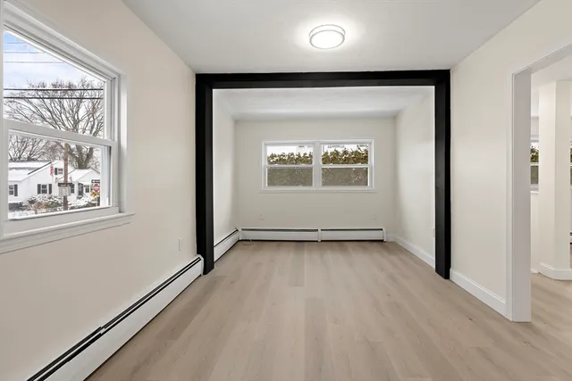 an empty room with wooden floor and windows