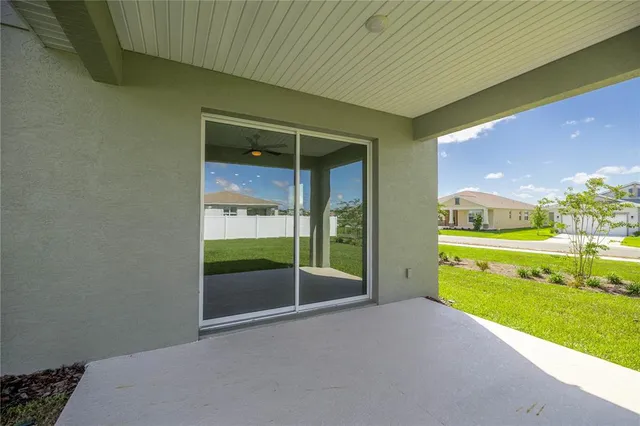 a view of an empty room and a kitchen