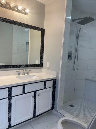 a bathroom with a sink a toilet and shower