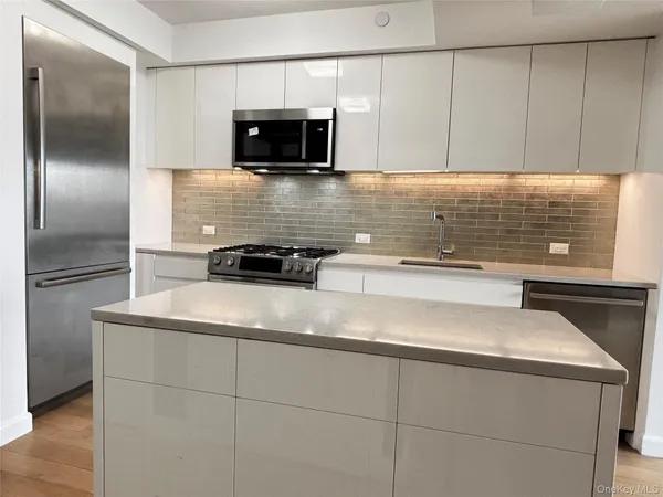 a kitchen with kitchen island a sink stainless steel appliances and cabinets