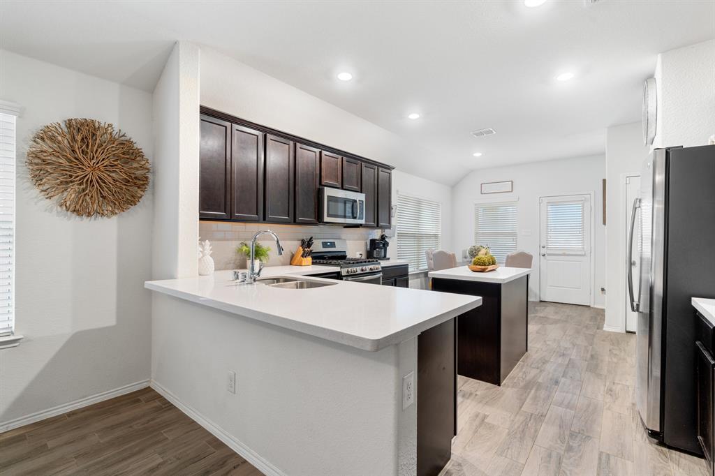 1490 Alamandine Avenue Cross Roads, TX 76227 - Photo 8 of 23 a kitchen with stainless steel appliances a sink stove and refrigerator