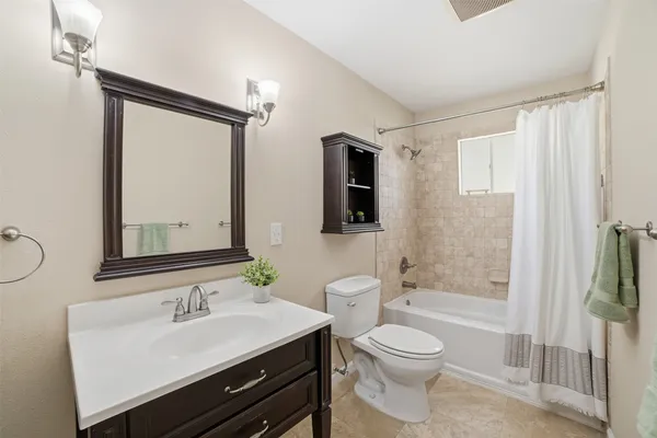 a bathroom with a toilet a sink a mirror and shower