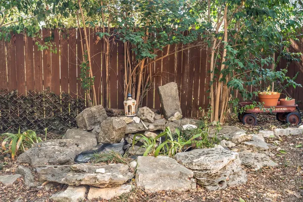 a view of a backyard with table and chairs and wooden fence