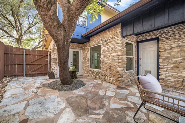 a view of a chair and tables in the back yard of the house