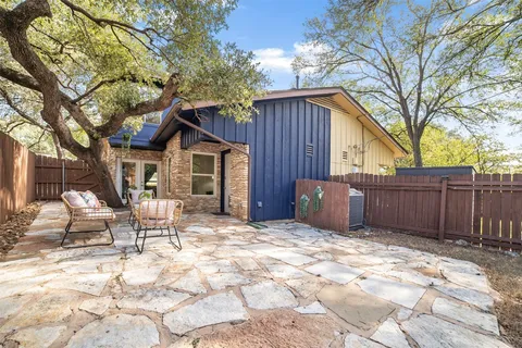 a view of a chair and tables in the back yard of the house