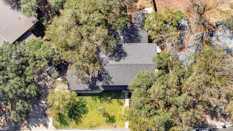 an aerial view of residential house with yard and outdoor seating