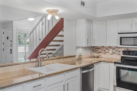 a kitchen with a sink stove and cabinets