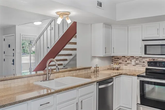 a kitchen with a sink stove and cabinets