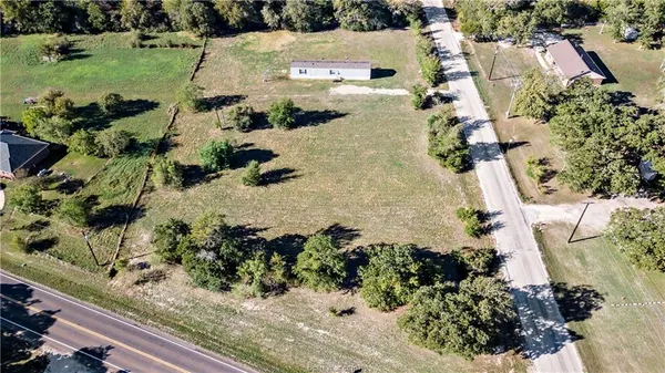 an aerial view of a house with a yard and lake view