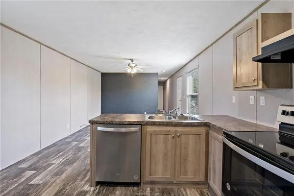 a kitchen with stainless steel appliances granite countertop a sink stove and cabinets