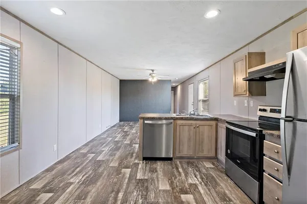 a kitchen with a sink cabinets stainless steel appliances and window