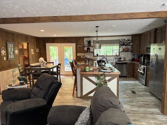 a living room with furniture a large window and stainless steel appliances