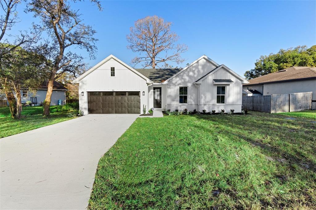 58 Bonita Road DeBary, FL 32713 - Photo 1 of 1 a front view of a house with a garden and trees