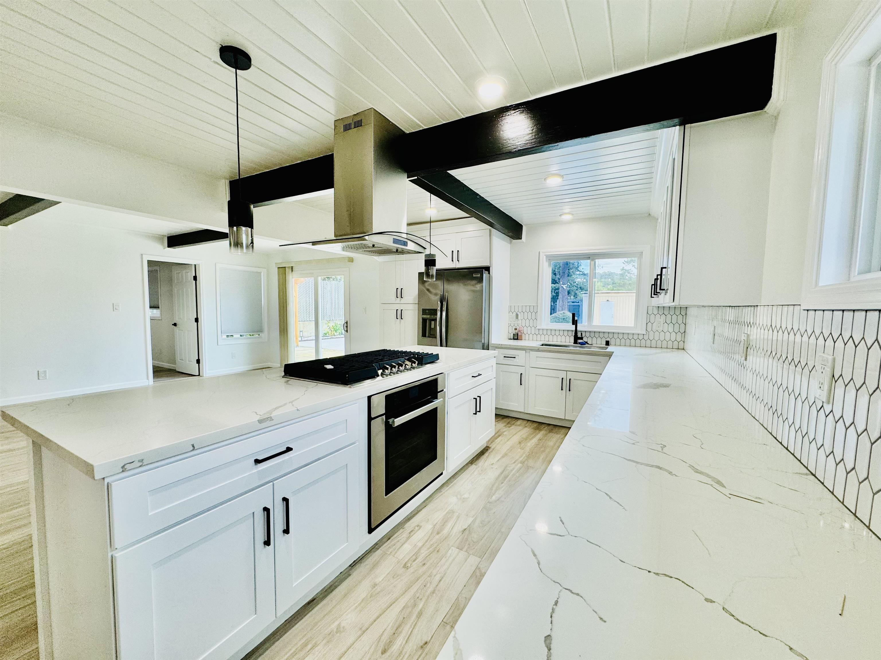 534 Rincon Road El Sobrante, CA 94803 - Photo 4 of 16 Kitchen featuring wood ceiling, light stone countertops, white cabinets, island range hood, and stainless steel appliances