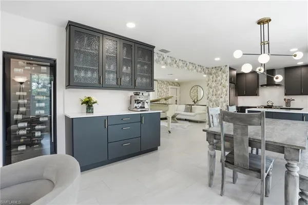 a living room with furniture a chandelier and kitchen view