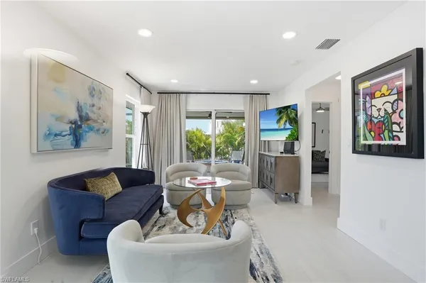 a living room with furniture and a large window with garden view